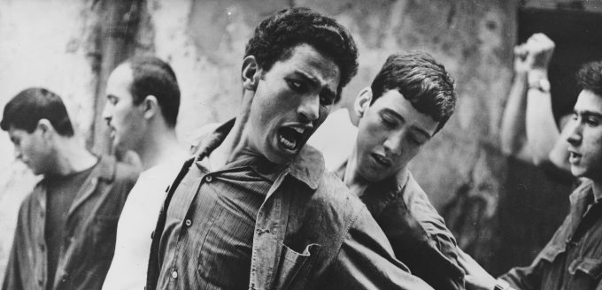 Brahim Haggiag (center, with arm outstretched) as revolutionary leader Ali La Pointe in a scene from Gillo Pontecorvo's THE BATTLE OF ALGIERS (1965). Photo courtesy Rialto Pictures.